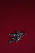Metallic witch on a broom figurine on a red background