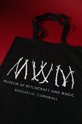 Black tote bag with white text and design on a red background