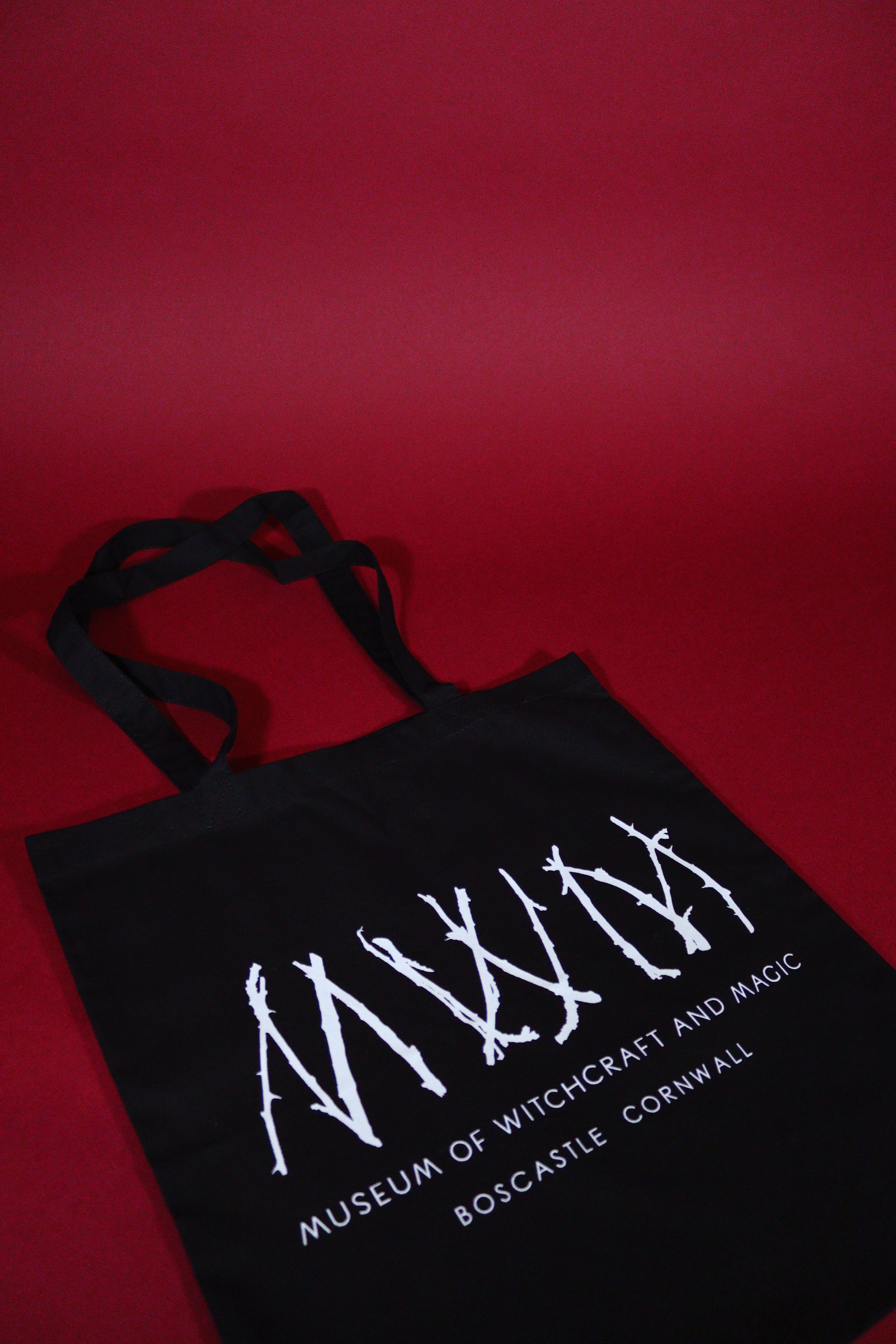 Black tote bag with white text on a red background