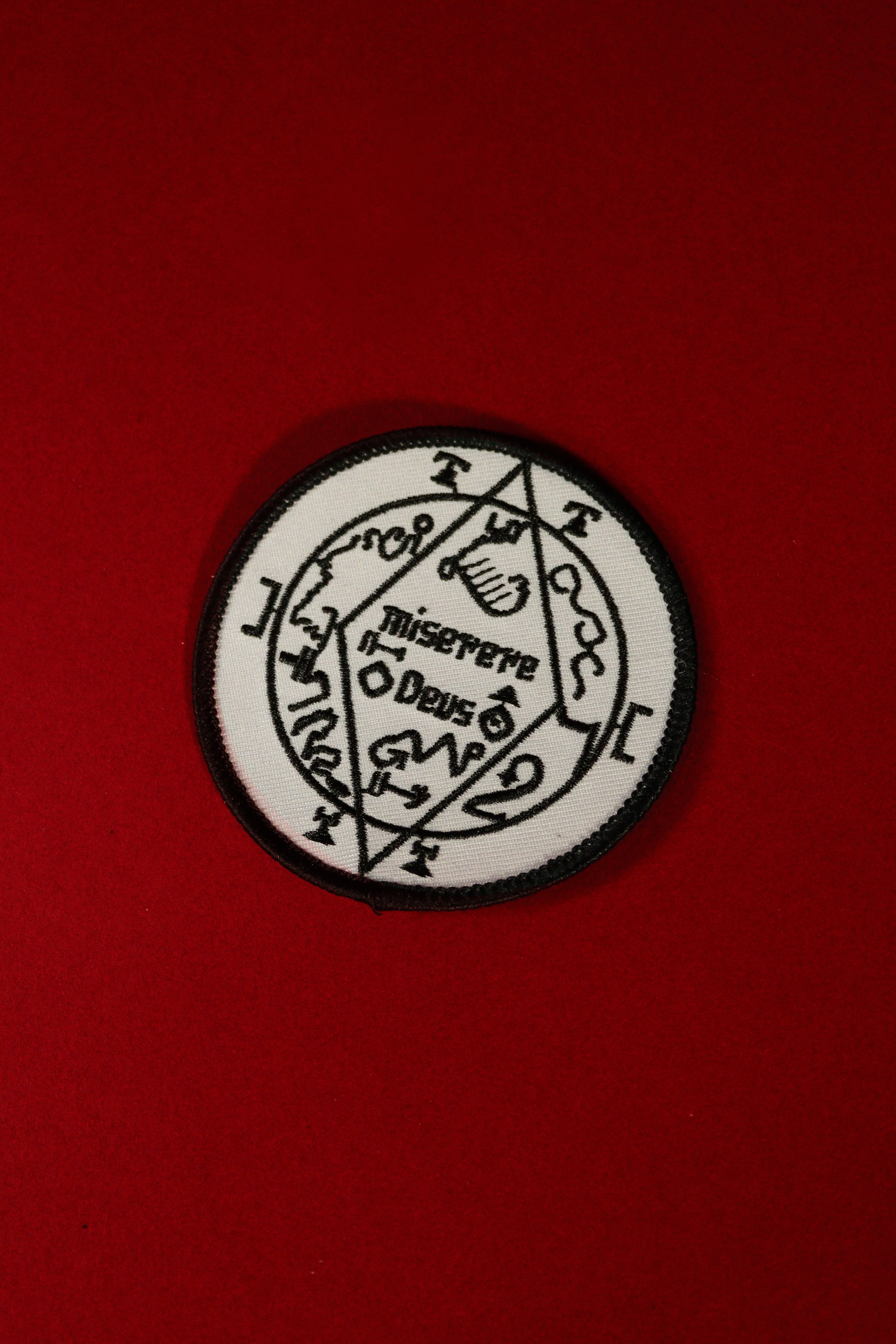 Black and white circular emblem with text on a red background