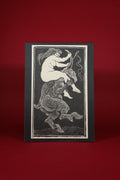 Card with a black and white illustration of a centaur on a red background