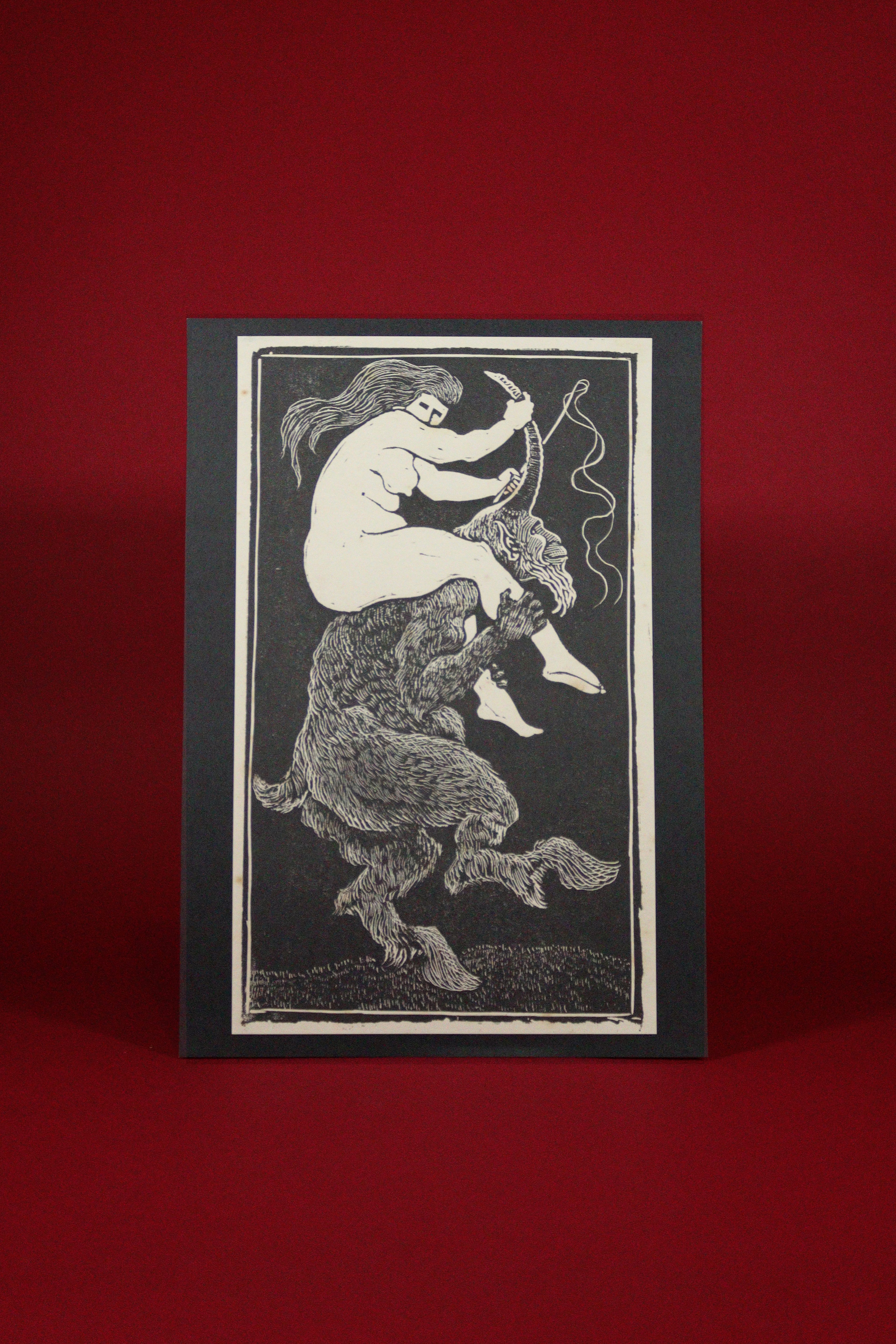 Card with a black and white illustration of a centaur on a red background