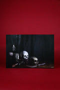 Still life arrangement with skulls and other objects on a dark surface against a red background
