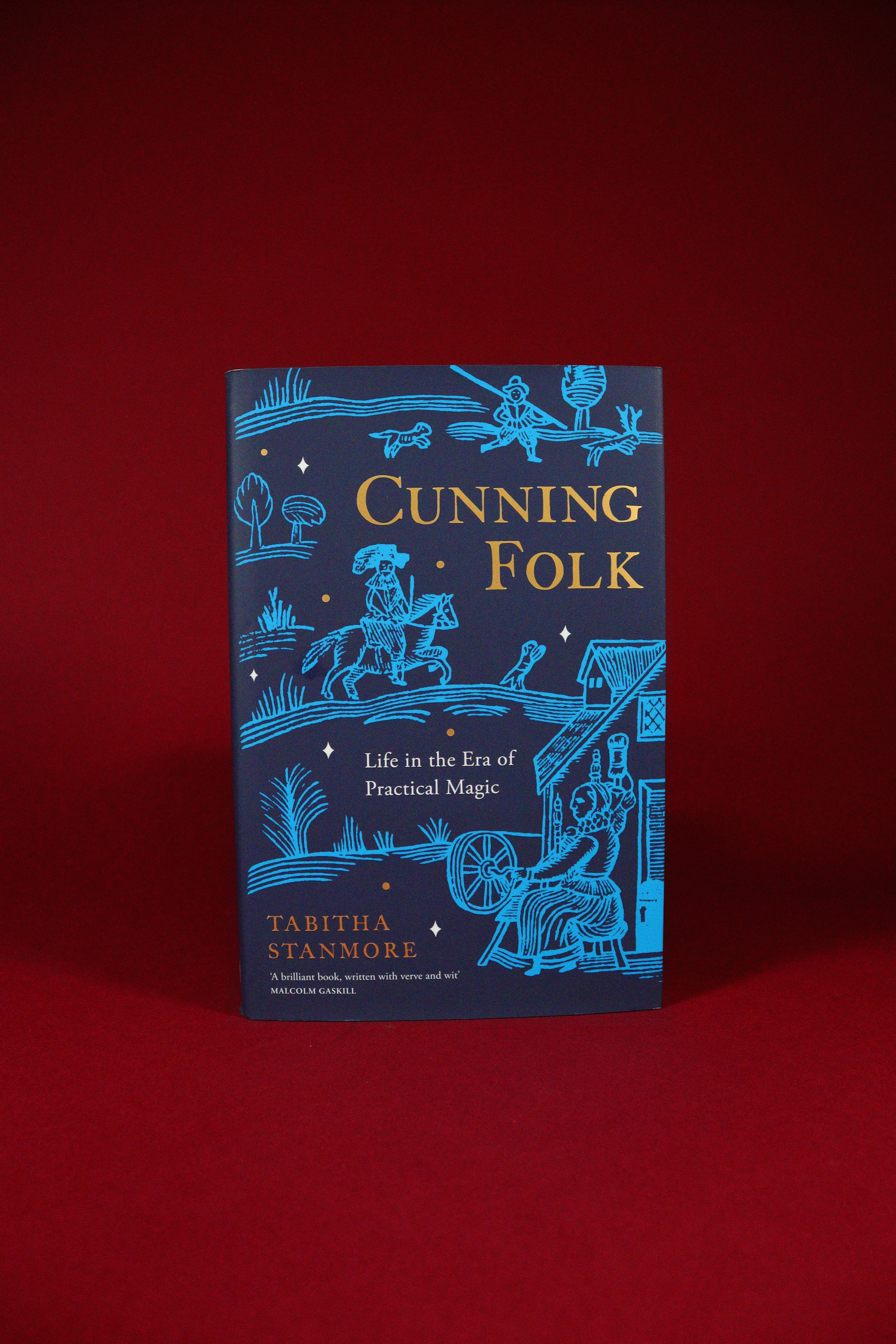 Book titled 'Cunning Folk' by Tabitha Stanmore on a red background