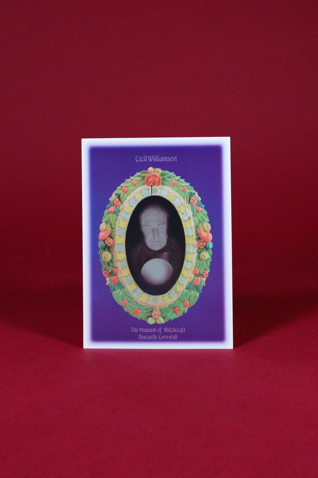 Decorative card with a portrait in an ornate frame on a red background