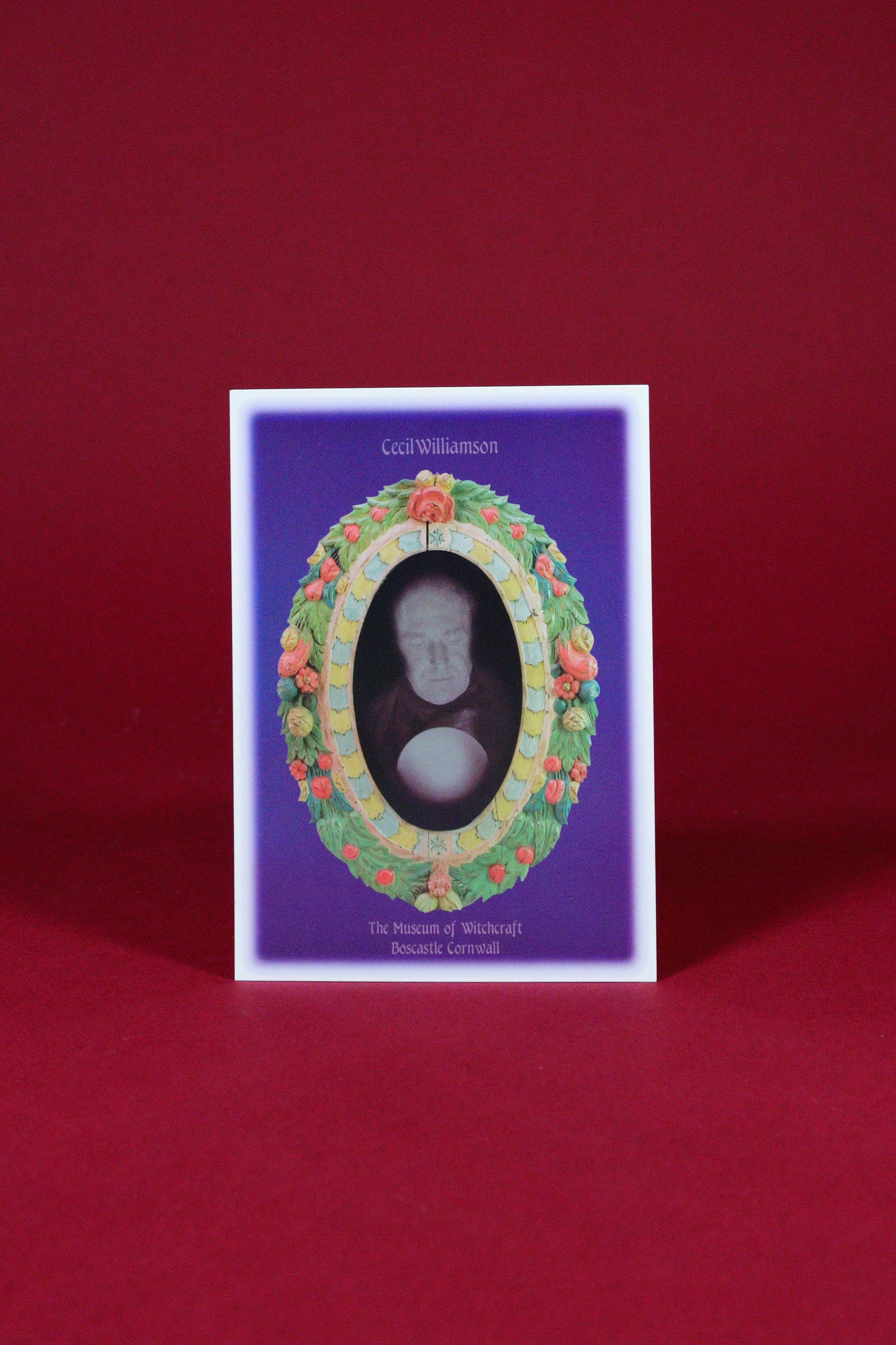 Decorative card with a portrait in an ornate frame on a red background