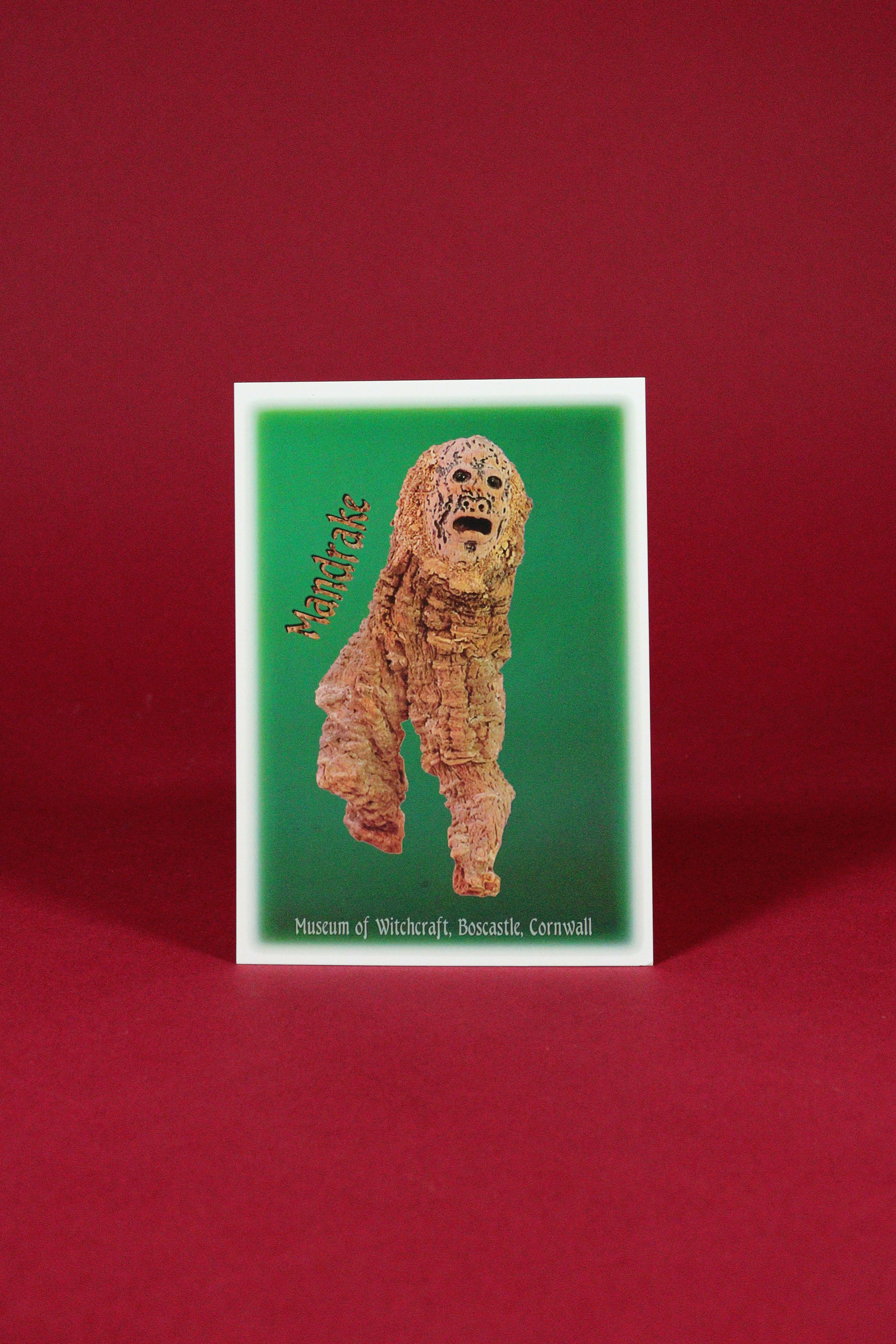 Card with a creature illustration on a green background against a red background