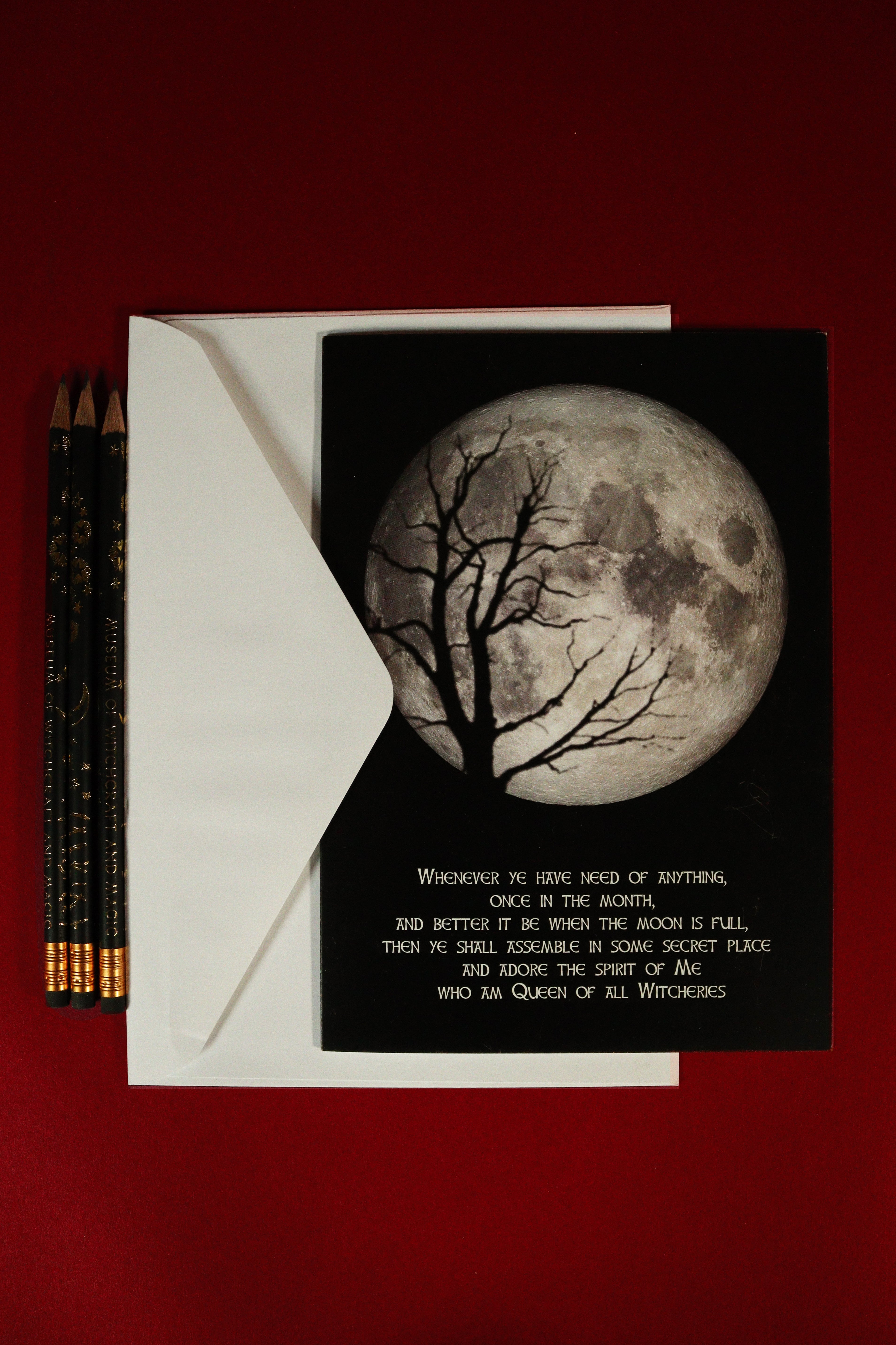 Greeting card with moon and tree design on a red background