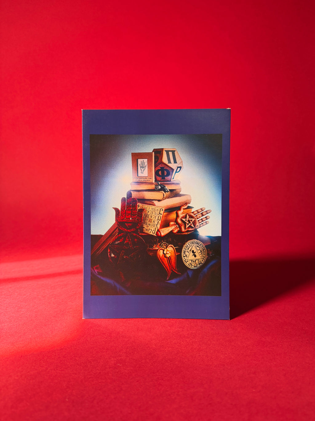 Card with a vintage wood carved objects on a red background