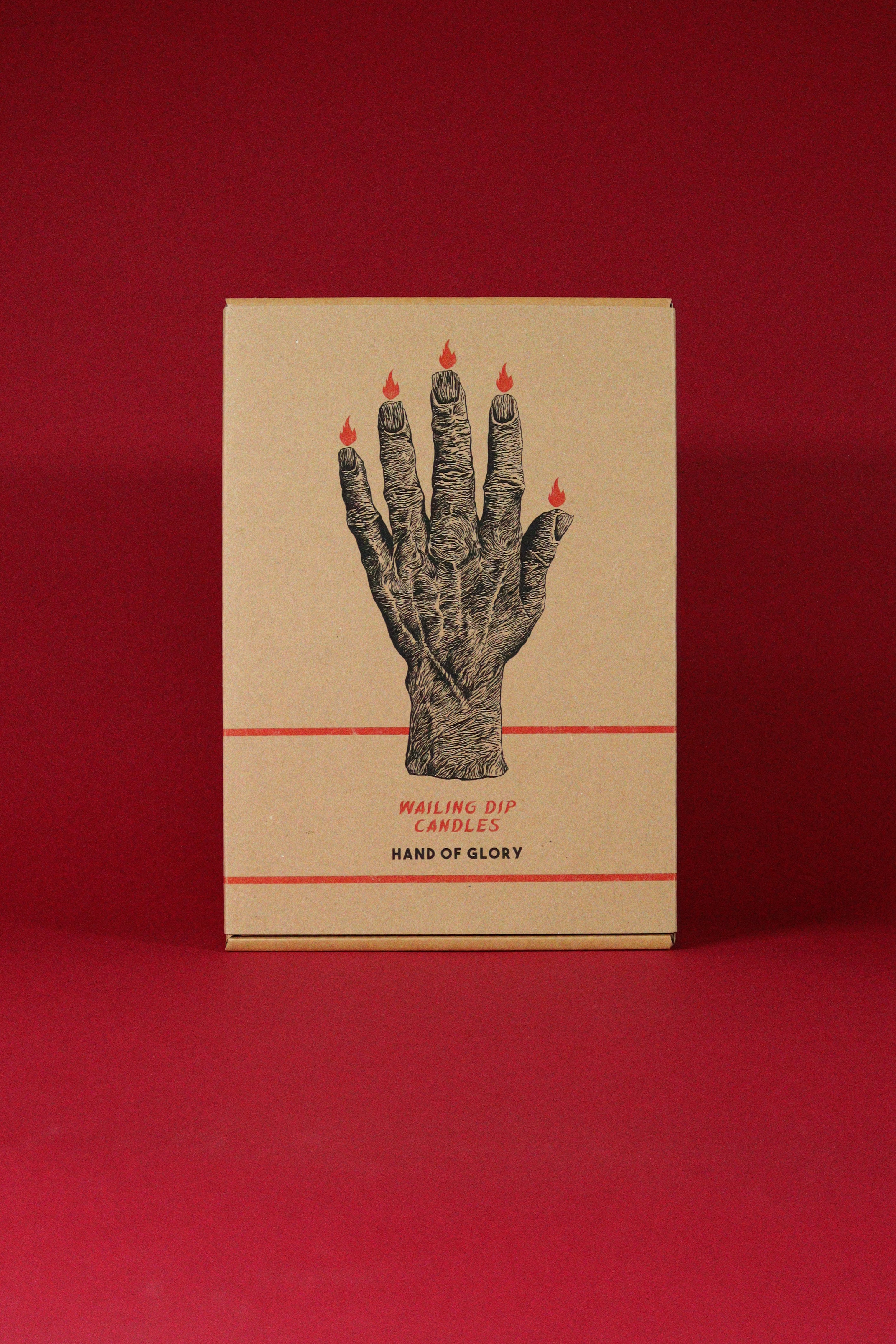 Cardboard box with a hand design and candles on a red background