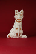 Decorative cat figurine with gold accents on a red background