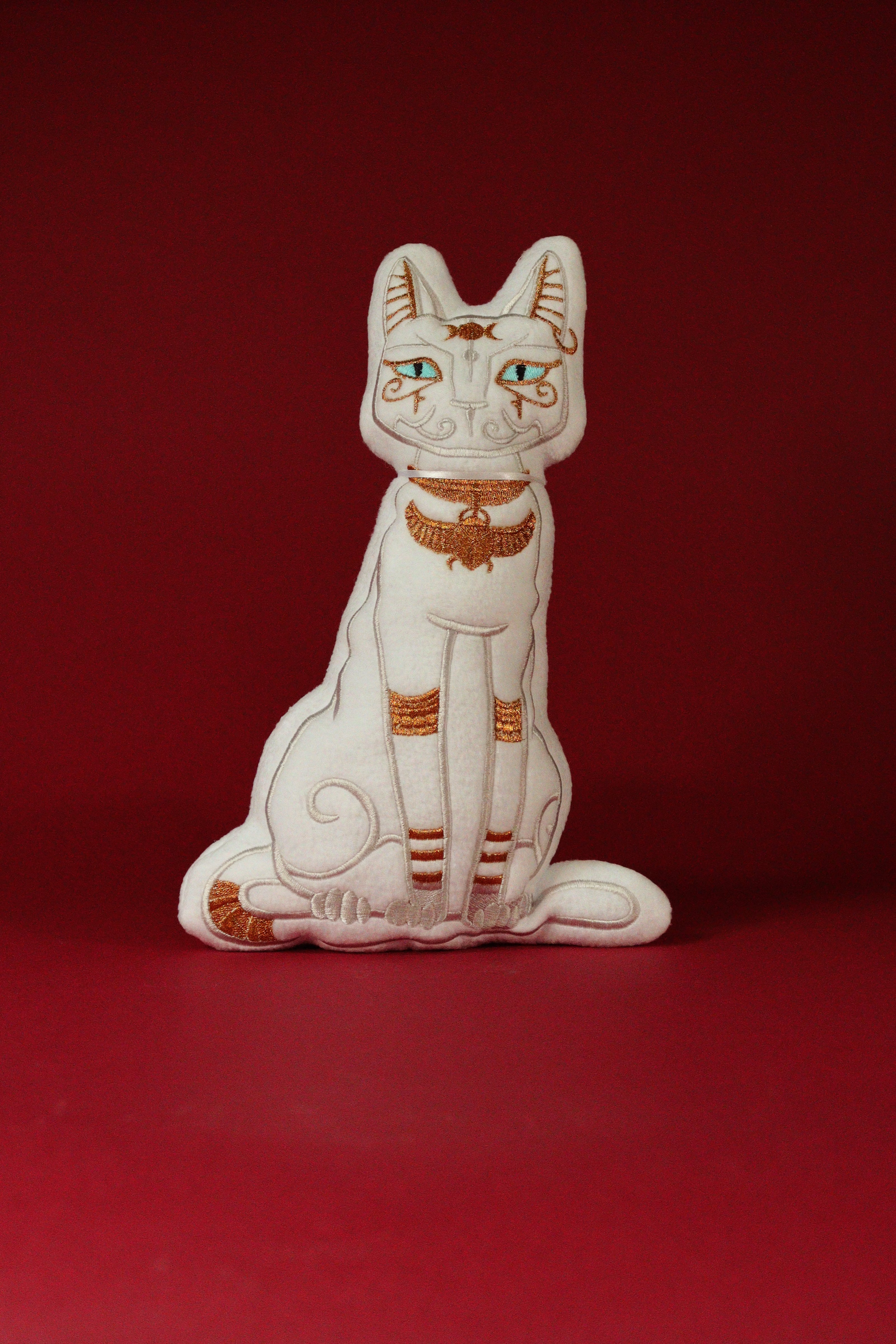 Decorative cat figurine with gold accents on a red background