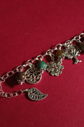Bracelet with tree of life and leaf charms on a red background