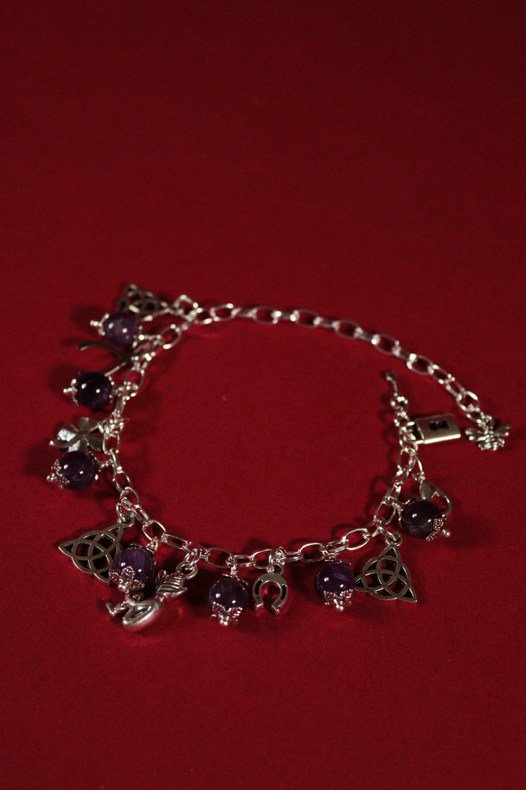 Silver bracelet with charms on a red background