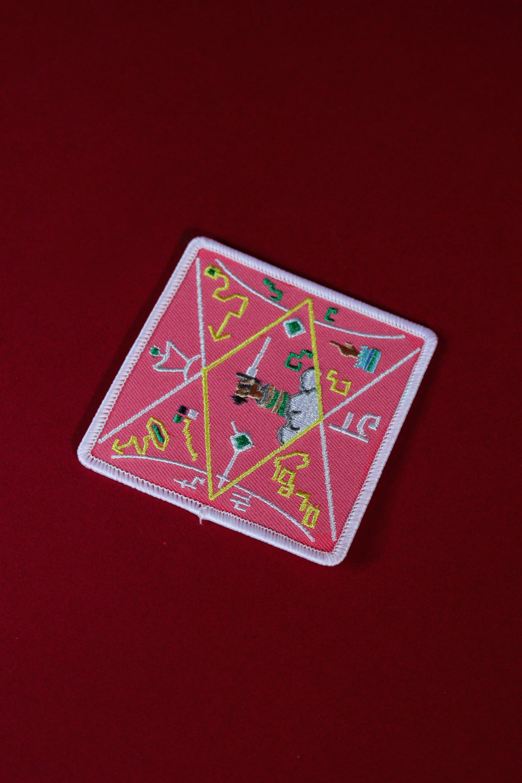 Decorative patch with geometric design on a red background