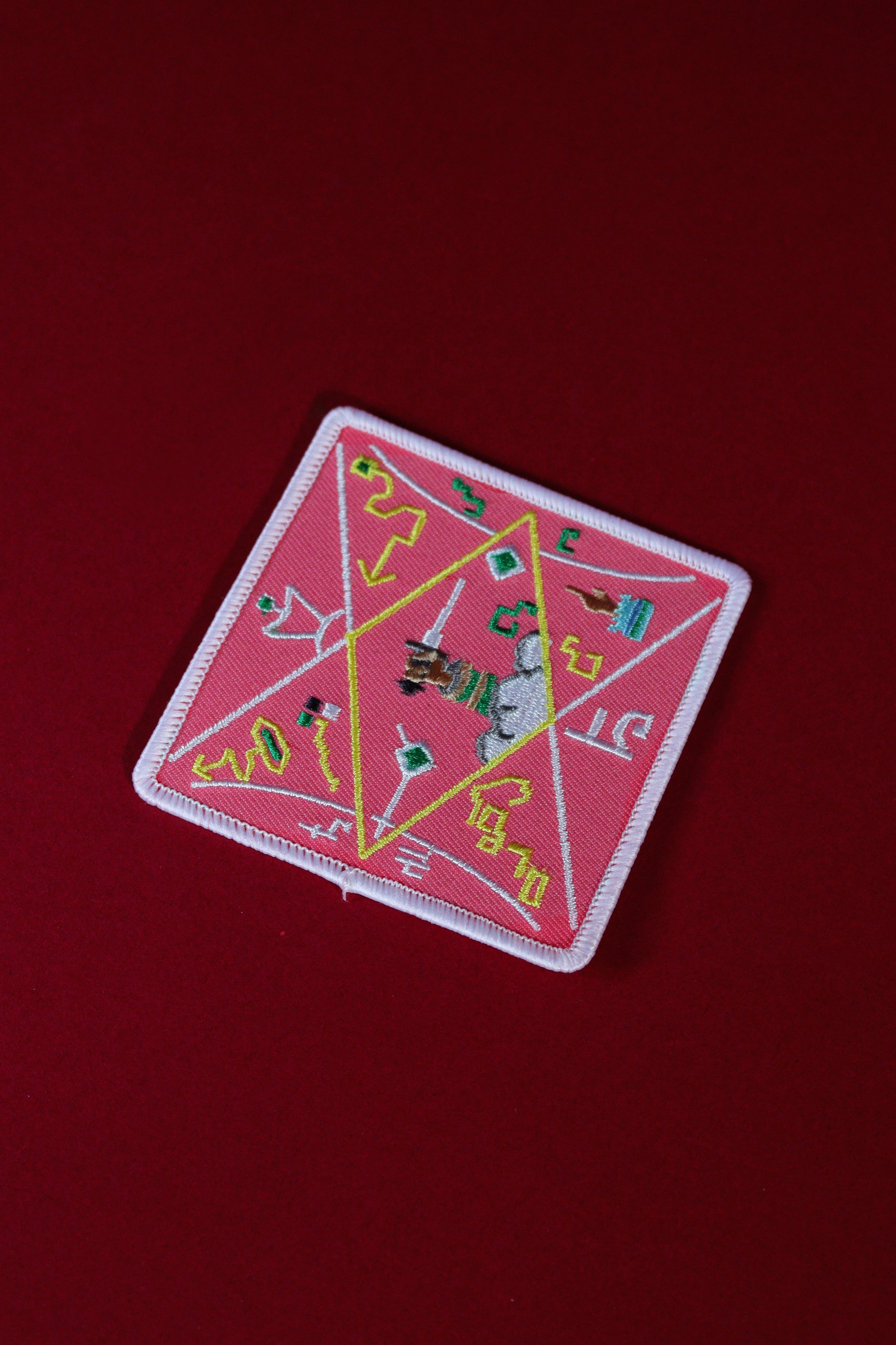 Decorative patch with geometric design on a red background