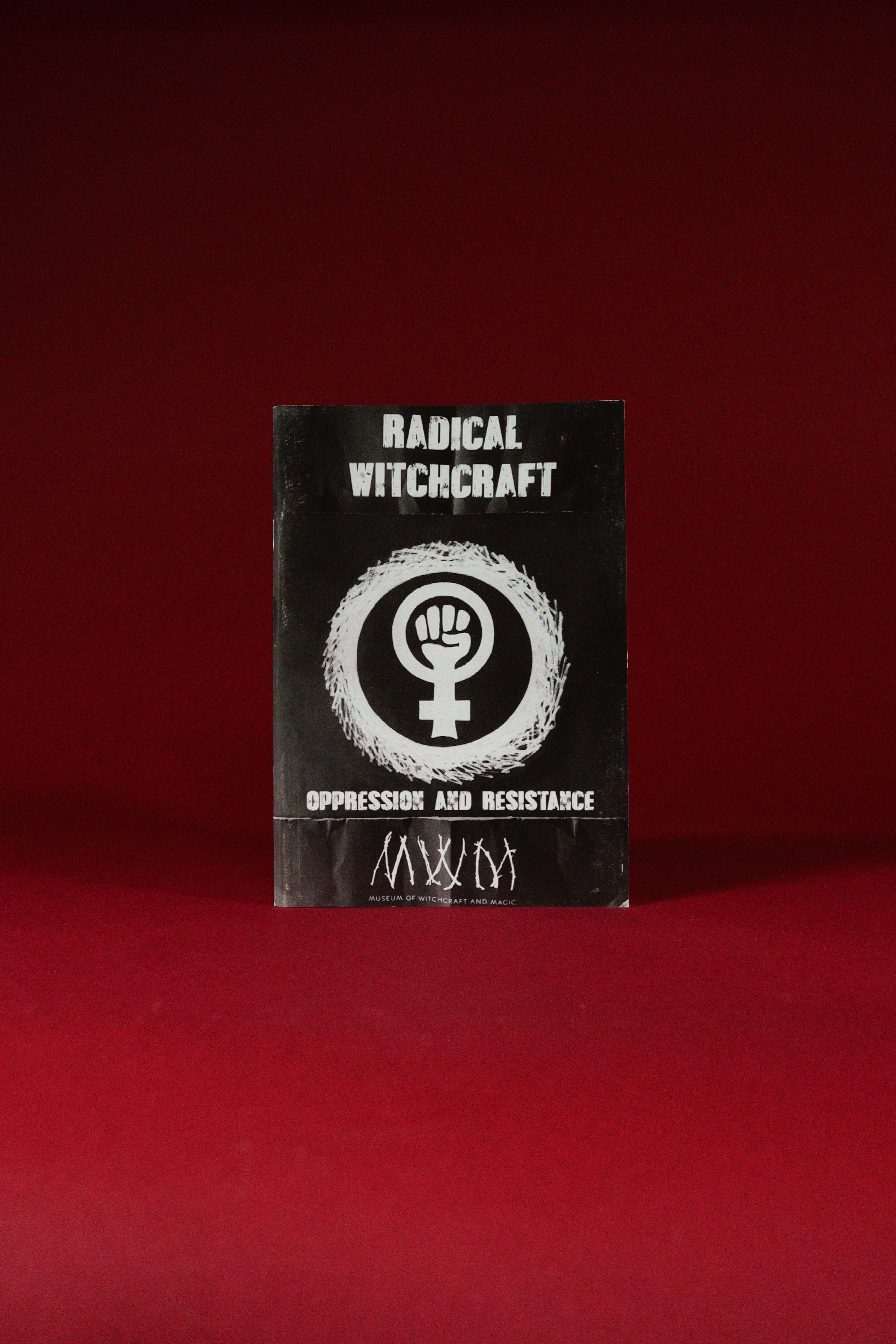Black book titled 'Radical Witchcraft' with a white symbol on a red background